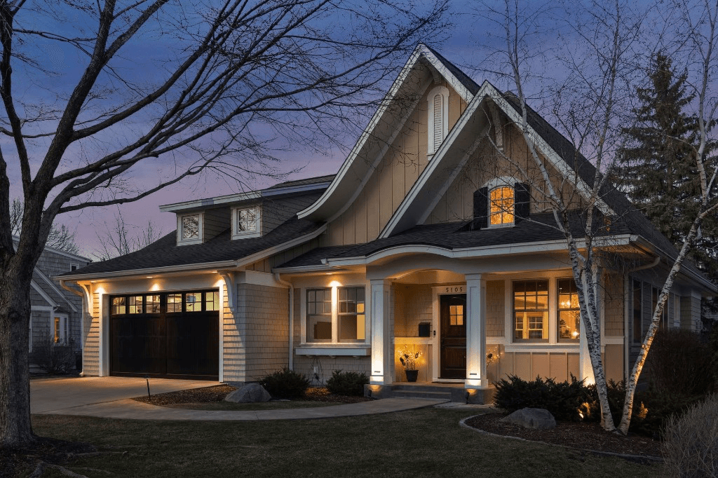 Two-story Edina home at dusk — lit windows, birch trees, and room to grow
