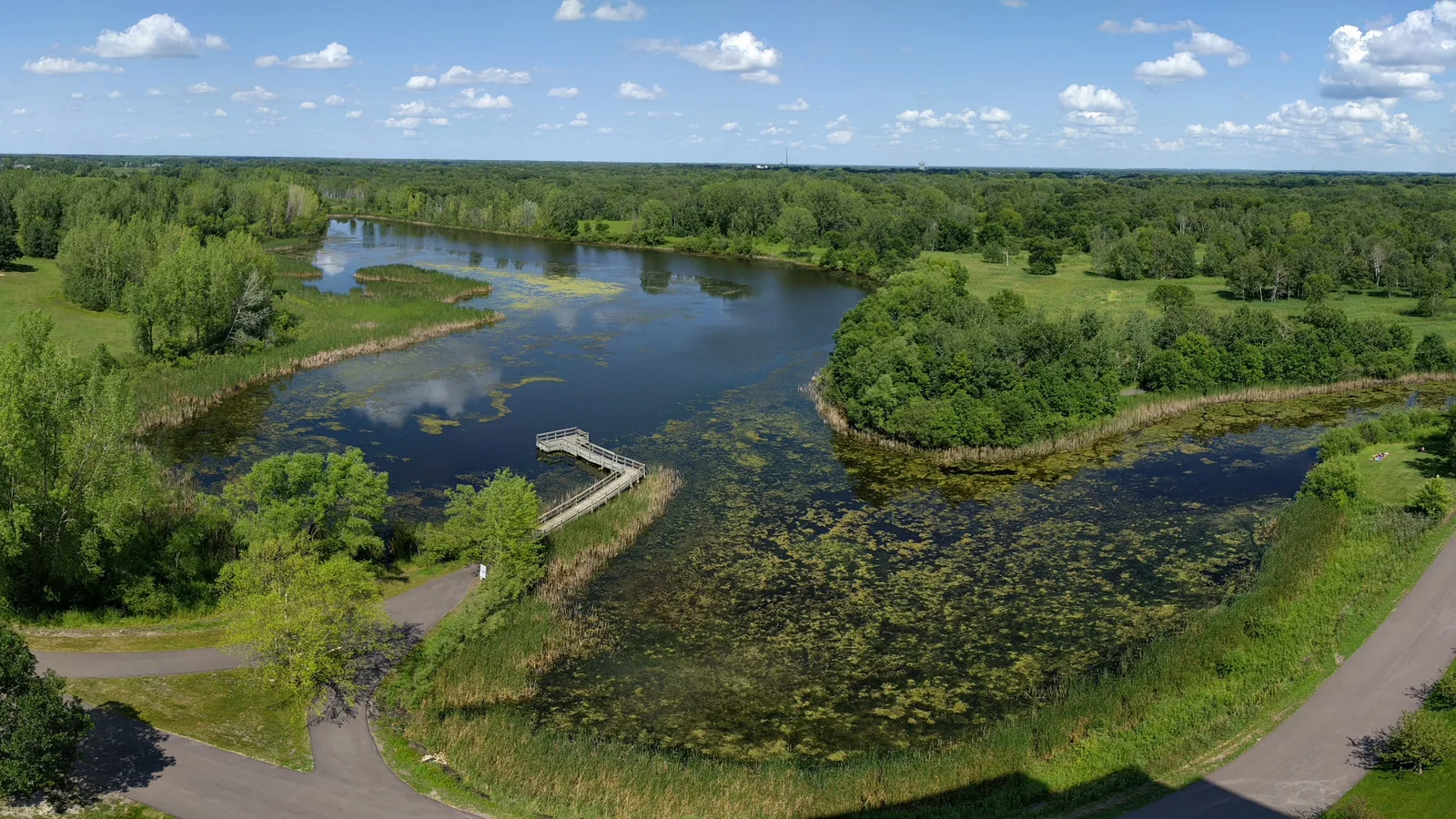 Aerial view of the pond, boardwalk and trails at Lochness Park in Blaine on a summer day with puffy clouds.